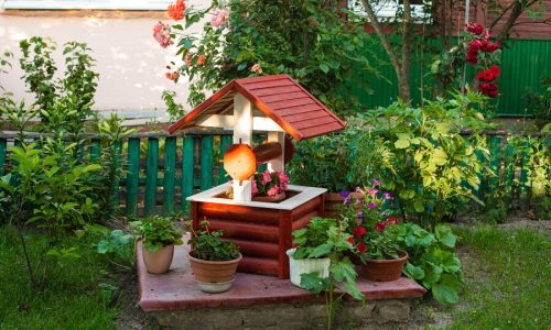 stock-photo-small-garden-backyard-fake-well-with-potted-flowers_132075-5927